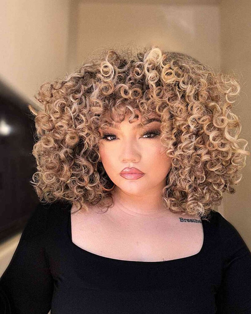 very thick curls with highlights for round face shapes